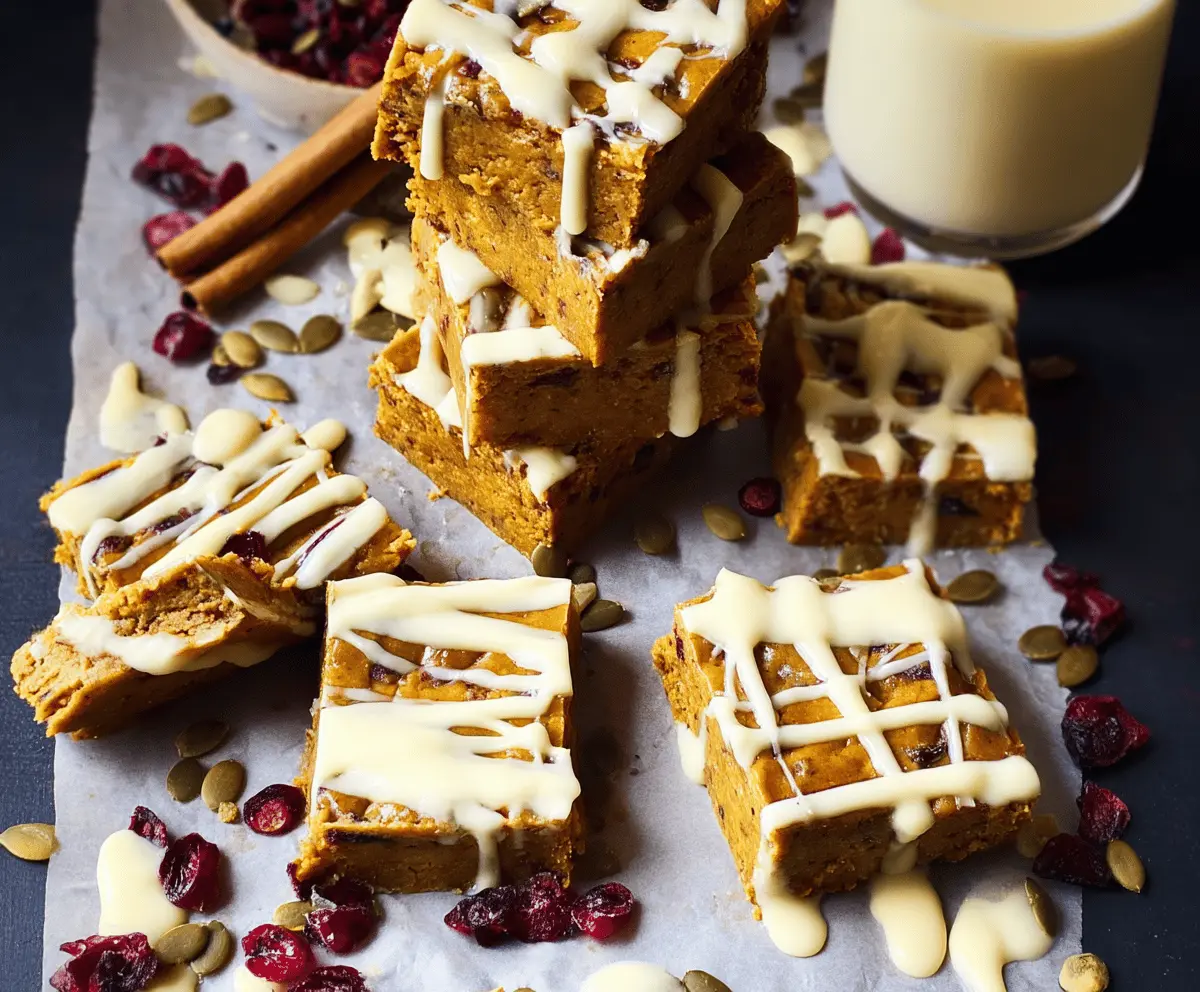 Delicious homemade Pumpkin Spiced Bars topped with white chocolate and a sprinkle of cinnamon, perfect for fall dessert.