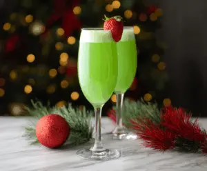 Festive Grinch Mimosa with green juice and holiday decor for a Christmas celebration