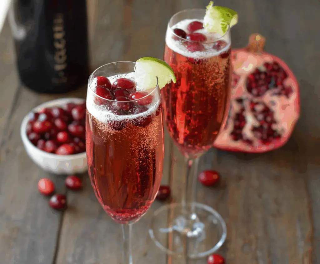 Frosted Cranberry Prosecco Pomegranate Cocktail in a elegant glass with fresh cranberries and pomegranate seeds.