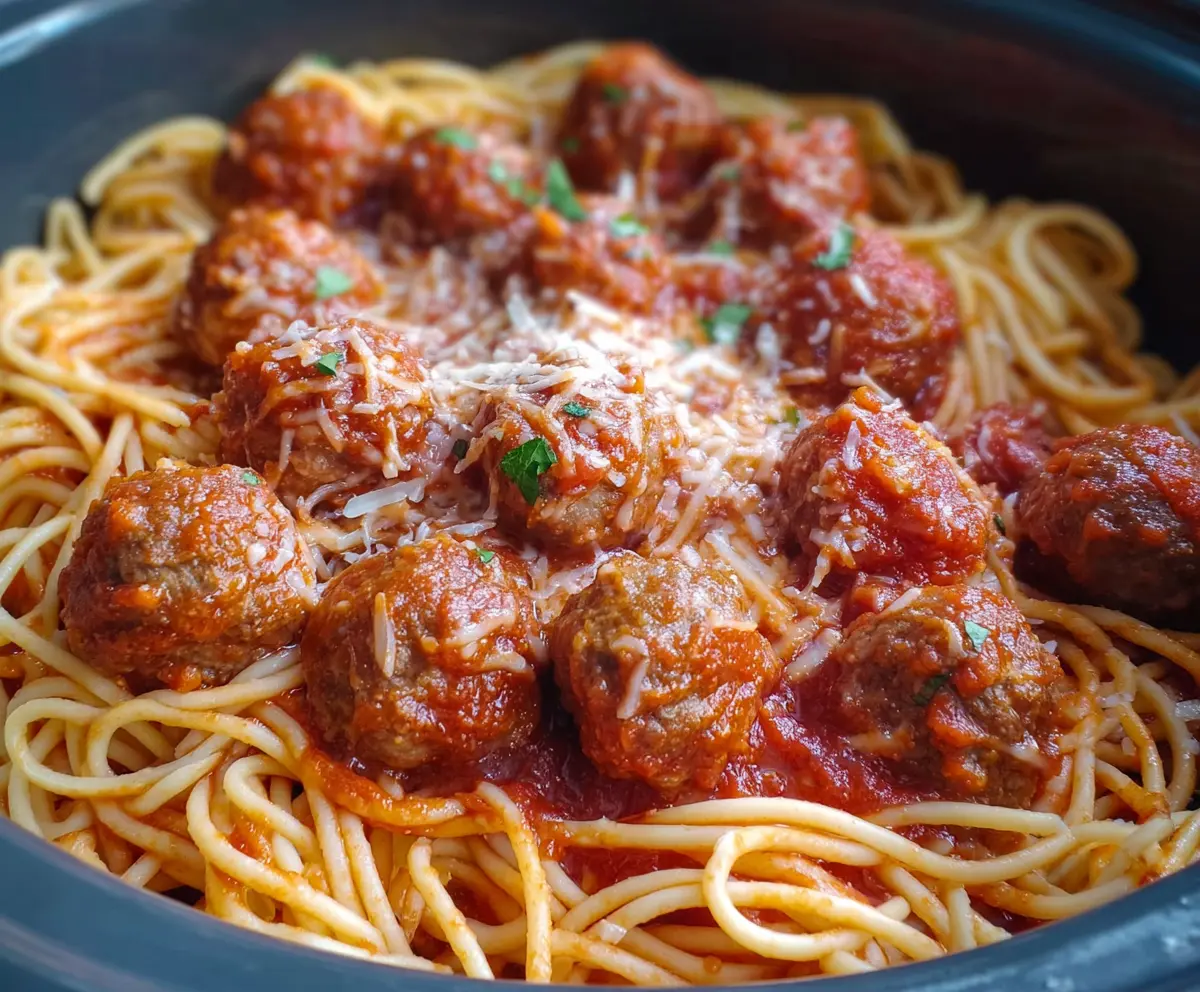 Delicious crockpot spaghetti with homemade meatballs in a savory tomato sauce served in a cozy kitchen.