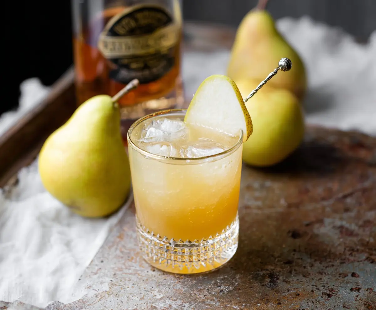 Ginger Pear Bourbon Cocktail in a glass garnished with pear slice and ginger zest