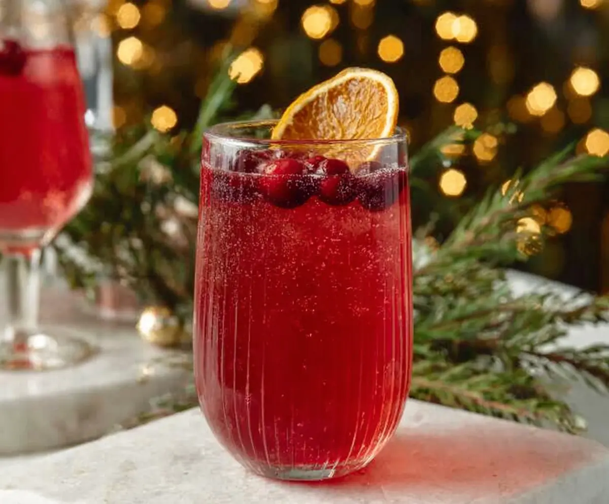 Festive Santa Spritz cocktail with red and white layered drink and holiday decorations
