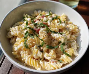 Delicious creamy cottage cheese pasta in a white bowl, garnished with herbs for a hearty vegetarian meal.