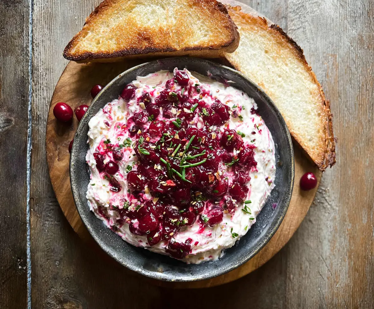 Creamy cranberry whipped Boursin dip served with fresh crackers for a festive appetizer.