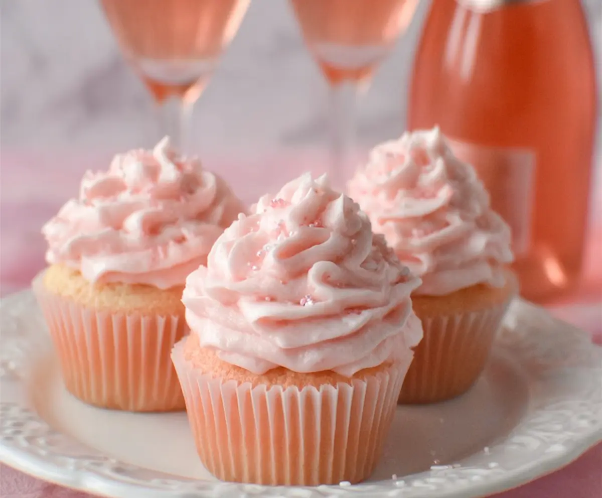 Delicious pink champagne cupcakes with pink frosting and sprinkles, perfect for celebrations.