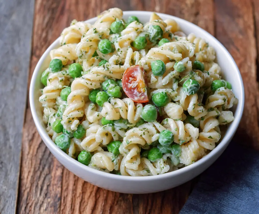 Fresh English Pea Pasta Salad with vibrant vegetables and herbs in a bowl