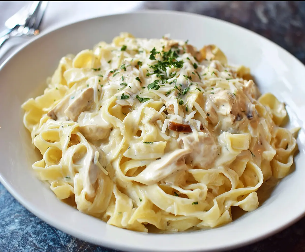 Creamy Fettuccine Alfredo pasta served with grated Parmesan cheese and fresh parsley.